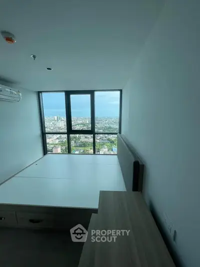 Modern bedroom with stunning city view from high-rise window, featuring sleek furniture and minimalist design.