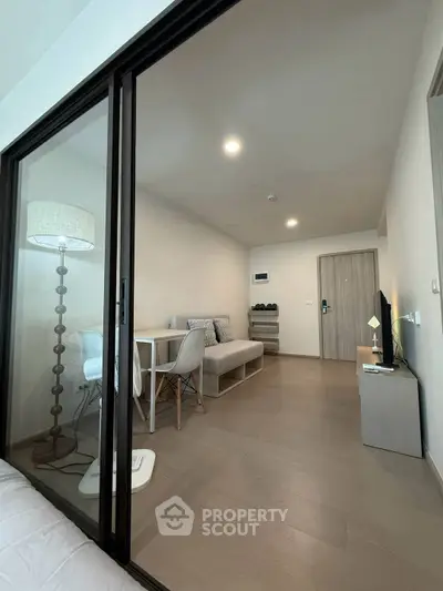 Modern living room with sleek furniture and glass partition in a stylish apartment.