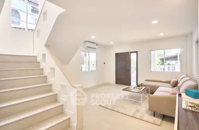 Spacious modern living room with natural light and elegant staircase