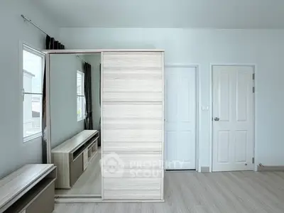 Spacious bedroom with modern wardrobe and natural light