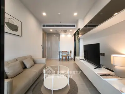 Modern living room with sleek furniture and stylish decor, featuring a comfortable sofa and large TV.