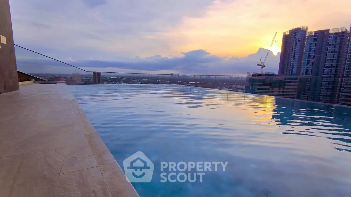 Stunning rooftop infinity pool with breathtaking city skyline view at sunset.