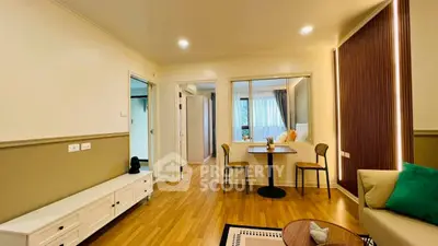 Modern living room with stylish decor and wooden flooring, featuring a cozy seating area and dining space.