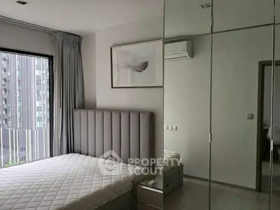 Modern bedroom with mirrored wardrobe and large window view.