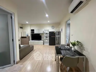 Modern living room with sleek furniture and open layout, featuring a cozy dining area and stylish decor.