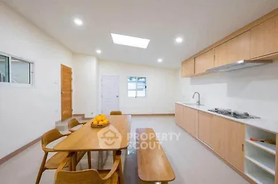 Spacious modern kitchen with wooden dining set and sleek cabinetry