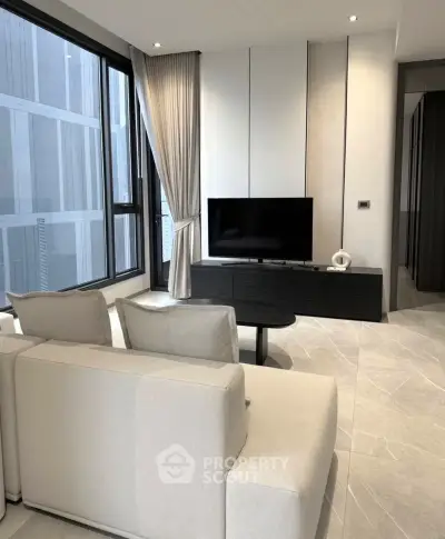 Modern living room with sleek design, large windows, and stylish furniture in a high-rise apartment.