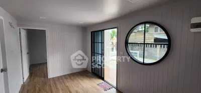 Modern interior with circular window and sliding glass door opening to patio.