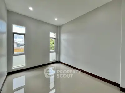 Spacious empty room with large windows and glossy tiled floor