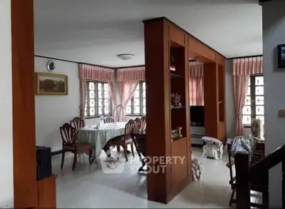 Spacious living and dining area with elegant wooden furniture and large windows.