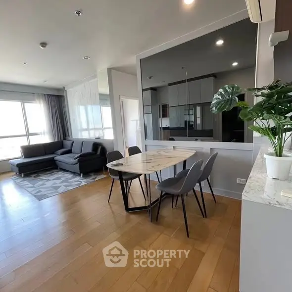Spacious modern living and dining area with sleek furniture and natural light.