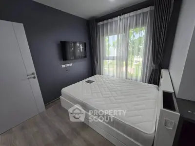 Modern bedroom with large window and minimalist decor, featuring a comfortable bed and wall-mounted TV.