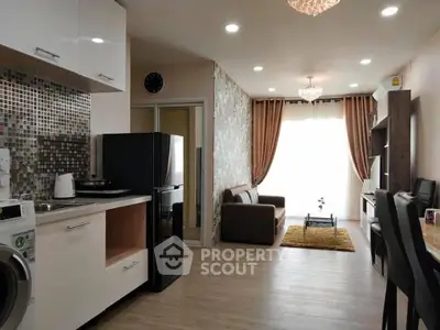 Modern open-layout living room with kitchen, featuring stylish decor and ample natural light.