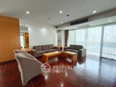 Spacious living room with modern furniture and large windows offering city views.
