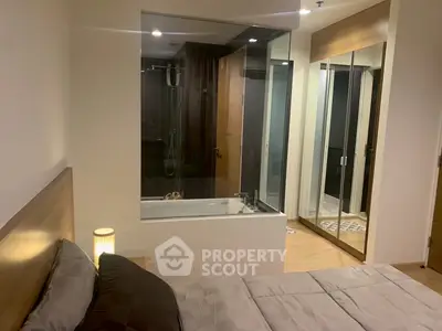 Modern bedroom with glass-walled bathroom and stylish decor