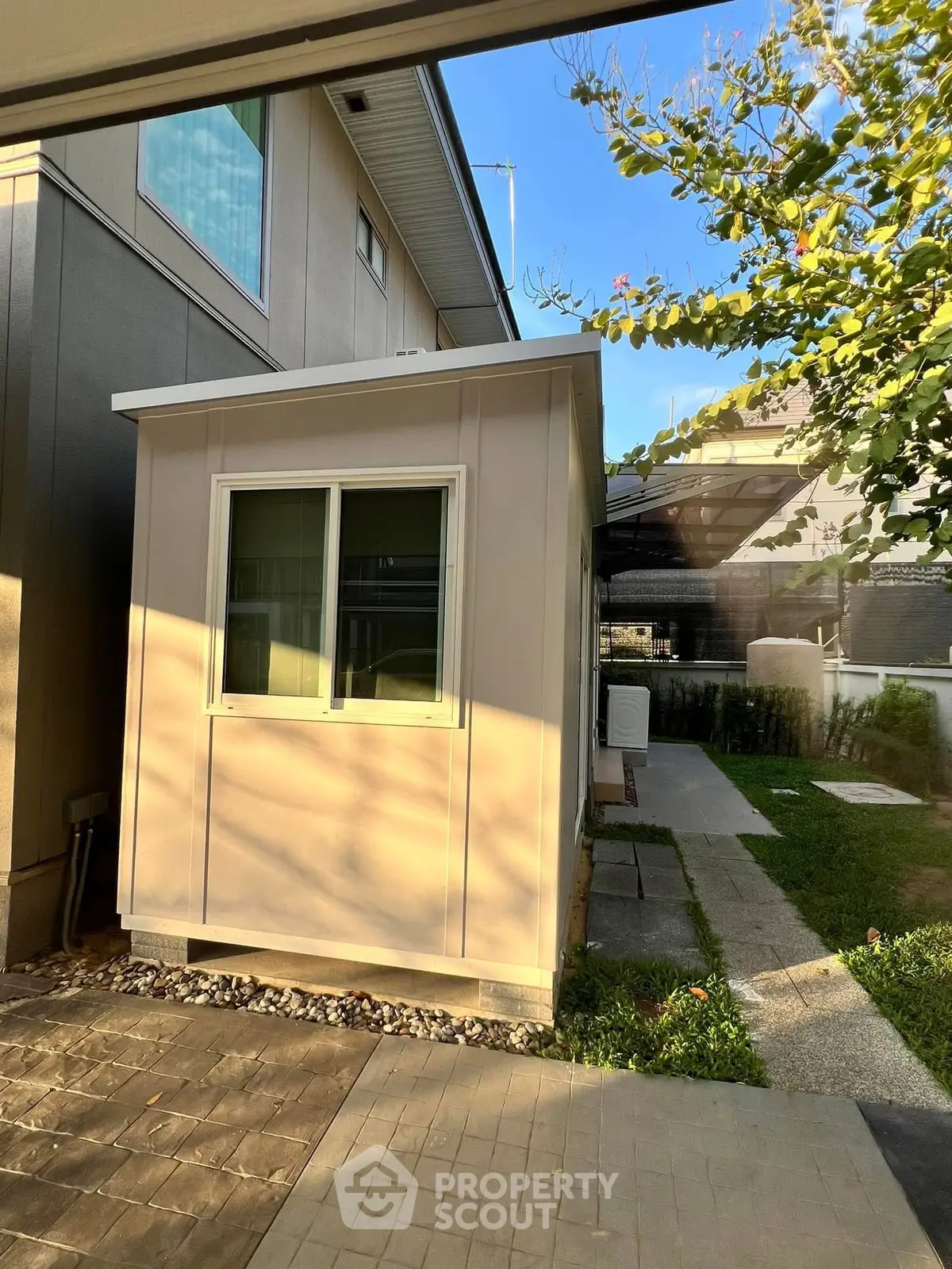 Charming backyard view with modern shed and lush greenery, perfect for outdoor relaxation and storage.