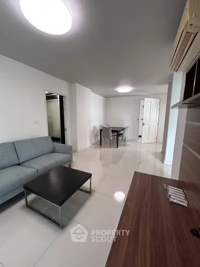 Modern living room with sleek furniture and bright lighting in a contemporary apartment.
