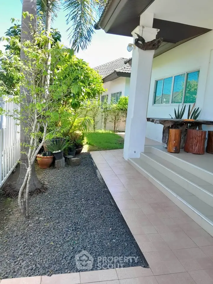 Charming garden view of a modern home with lush greenery and stylish outdoor seating.