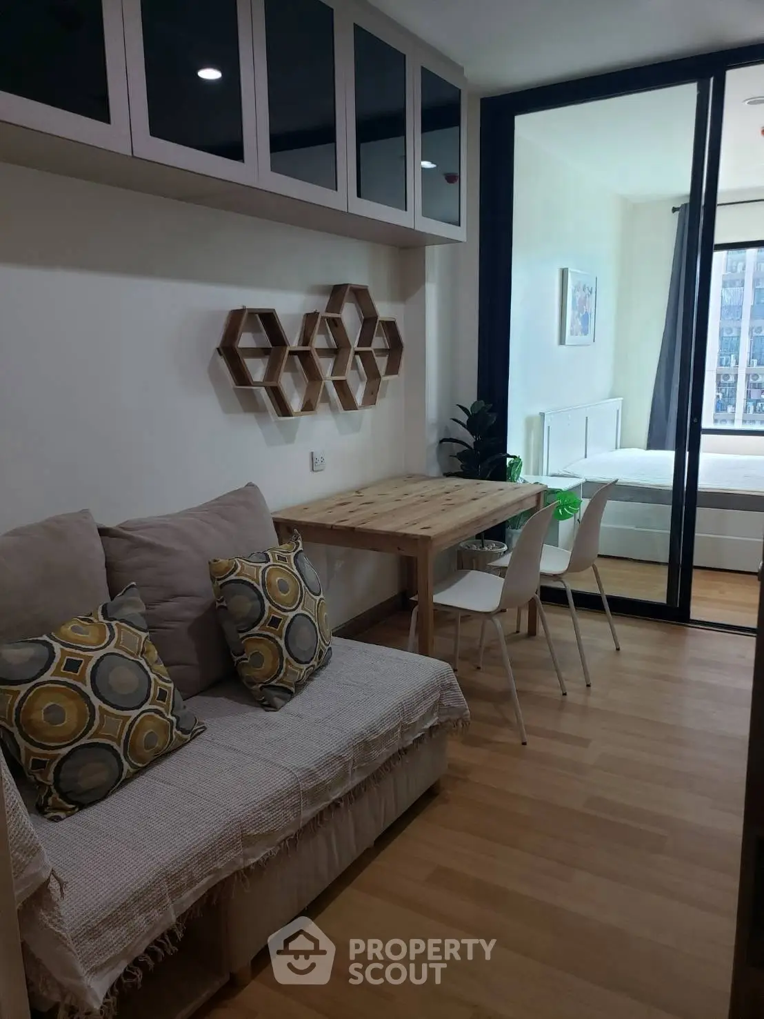 Modern apartment with cozy living area and stylish decor, featuring a compact dining space and bedroom view.