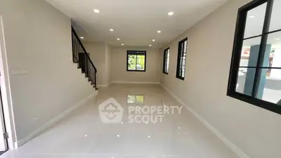 Spacious modern living room with sleek tile flooring and large windows for natural light.