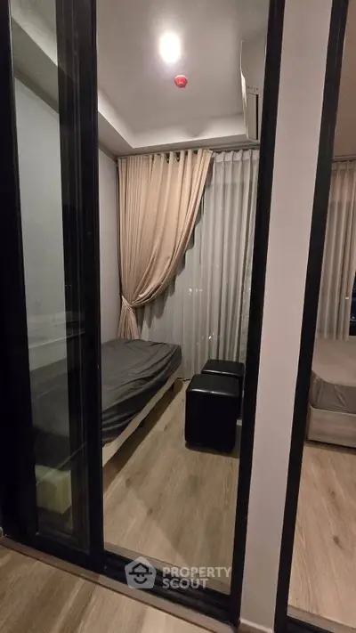 Modern bedroom with glass partition and elegant curtains in a stylish apartment.