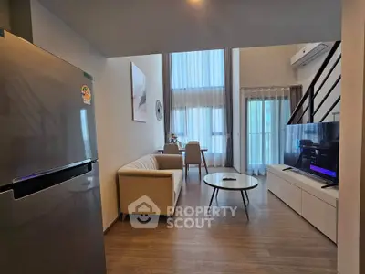 Modern living room with high ceilings and stylish decor in a contemporary apartment.