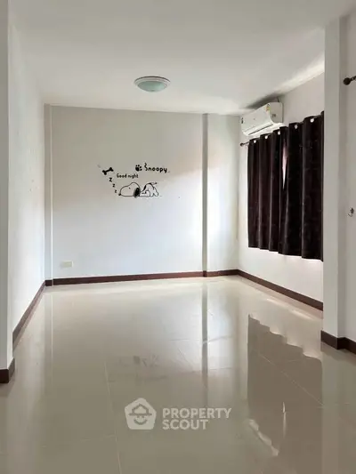 Spacious empty room with glossy tiled floor and air conditioning, perfect for customization.