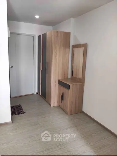 Modern minimalist bedroom with sleek wooden wardrobe and vanity set.