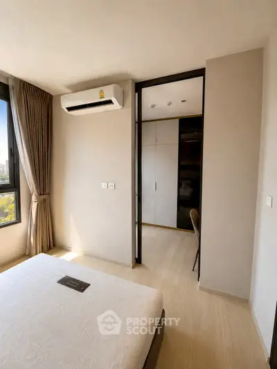 Modern bedroom with air conditioning and natural light in a stylish apartment.