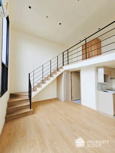 Modern loft apartment with wooden staircase and open kitchen layout