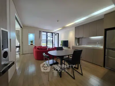 Modern open-plan living room with sleek kitchen and stylish red sofa