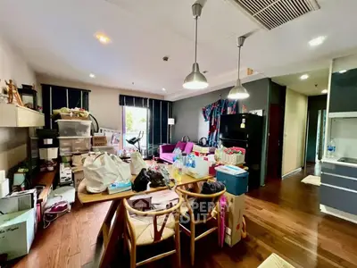 Spacious living room with modern decor and ample natural light, featuring stylish furniture and hardwood floors.