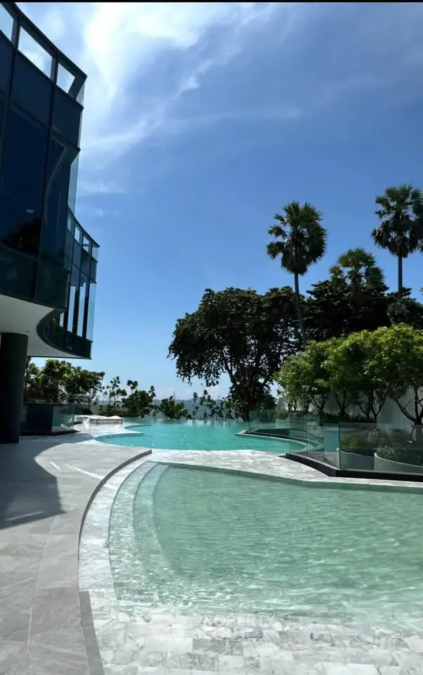 Luxurious modern pool area with stunning views and lush greenery, perfect for relaxation and leisure.