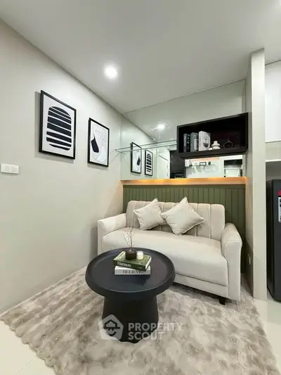 Modern living room with cozy sofa, stylish decor, and plush rug in a compact space.