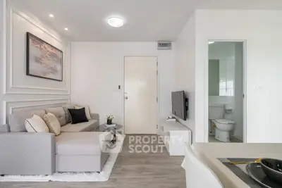 Modern living room with cozy sofa and TV near bathroom entrance