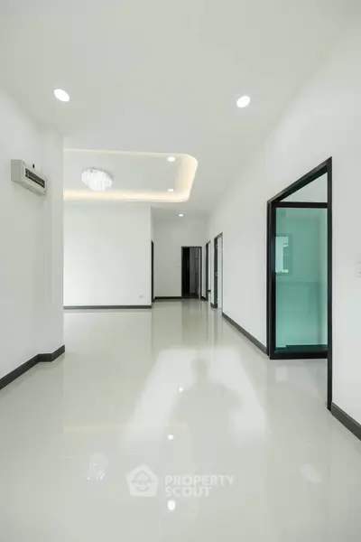 Spacious modern interior with glossy floors and elegant lighting, perfect for contemporary living.