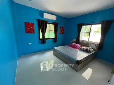 Bright blue bedroom with modern decor and large window for natural light.