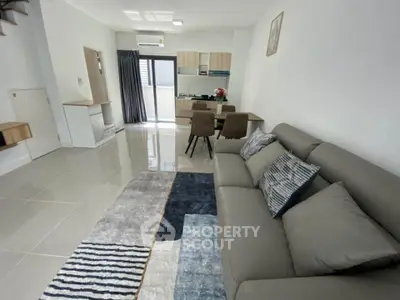 Modern open-plan living room with stylish furniture and sleek kitchen design