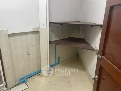 Compact storage room with corner shelves and tiled flooring