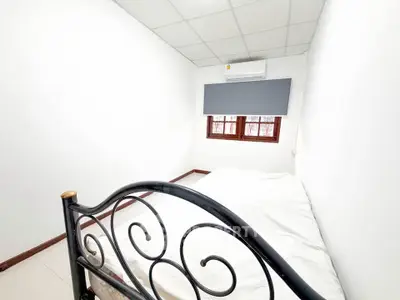 Cozy minimalist bedroom with metal bed frame and air conditioning