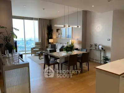 Modern dining and living area with city view, elegant decor, and natural light.