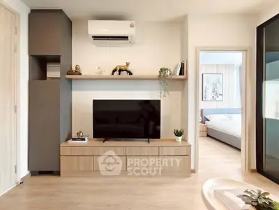 Modern living room with sleek TV unit and glimpse of cozy bedroom