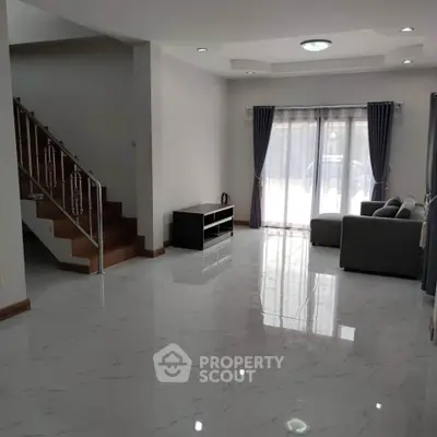 Spacious modern living room with marble flooring and elegant staircase