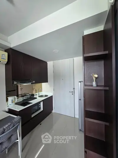 Modern kitchen with sleek cabinetry and gas stove in a compact apartment