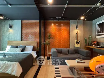 Stylish modern studio with exposed brick wall and cozy furnishings