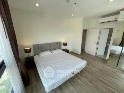 Spacious bedroom with modern decor and large windows in a stylish apartment.