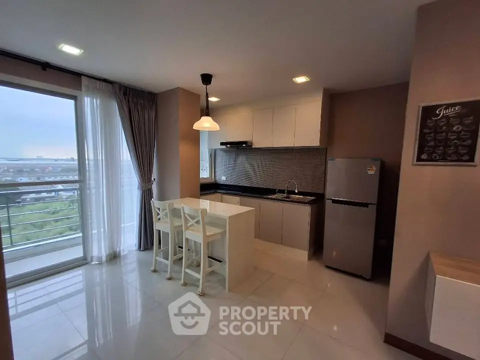 Modern kitchen with open layout and balcony view in a stylish apartment.