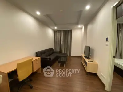 Modern living room with sleek furniture and wooden flooring in a cozy apartment.