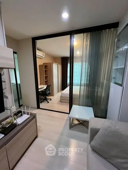 Modern studio apartment with glass partition, cozy living area, and stylish furnishings.