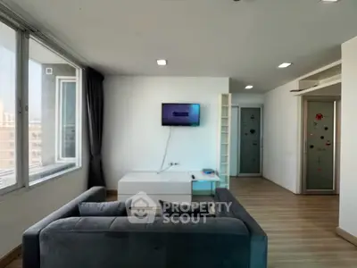 Modern living room with large window and sleek furniture in a stylish apartment.